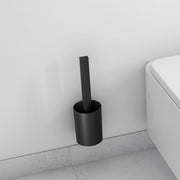 Matte black cylindrical toilet brush holder mounted on wall next to white toilet.