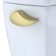 Polished brass trip lever with curved handle mounted on white toilet tank.