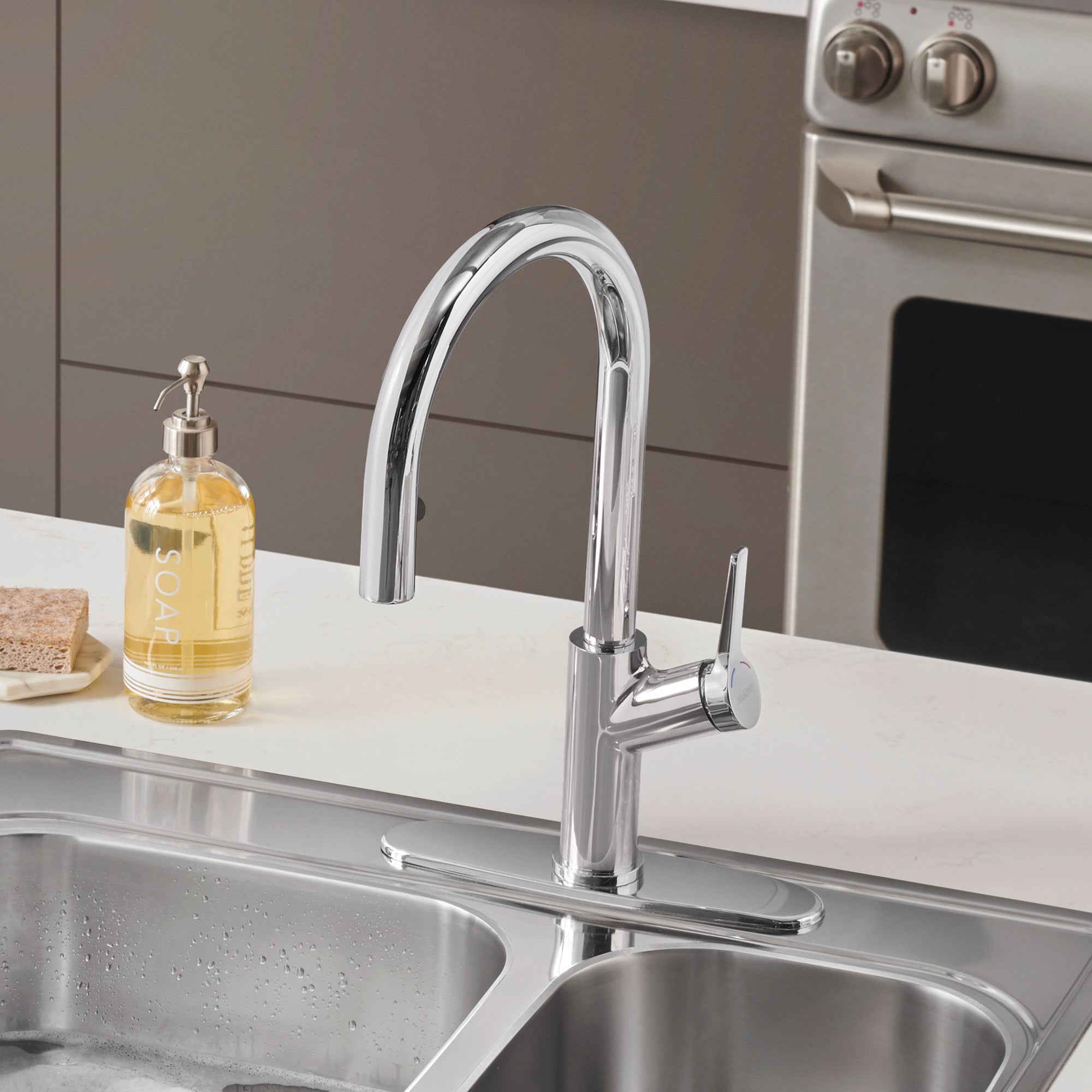 Chrome pull-down kitchen faucet with curved spout and single lever handle over double sink.