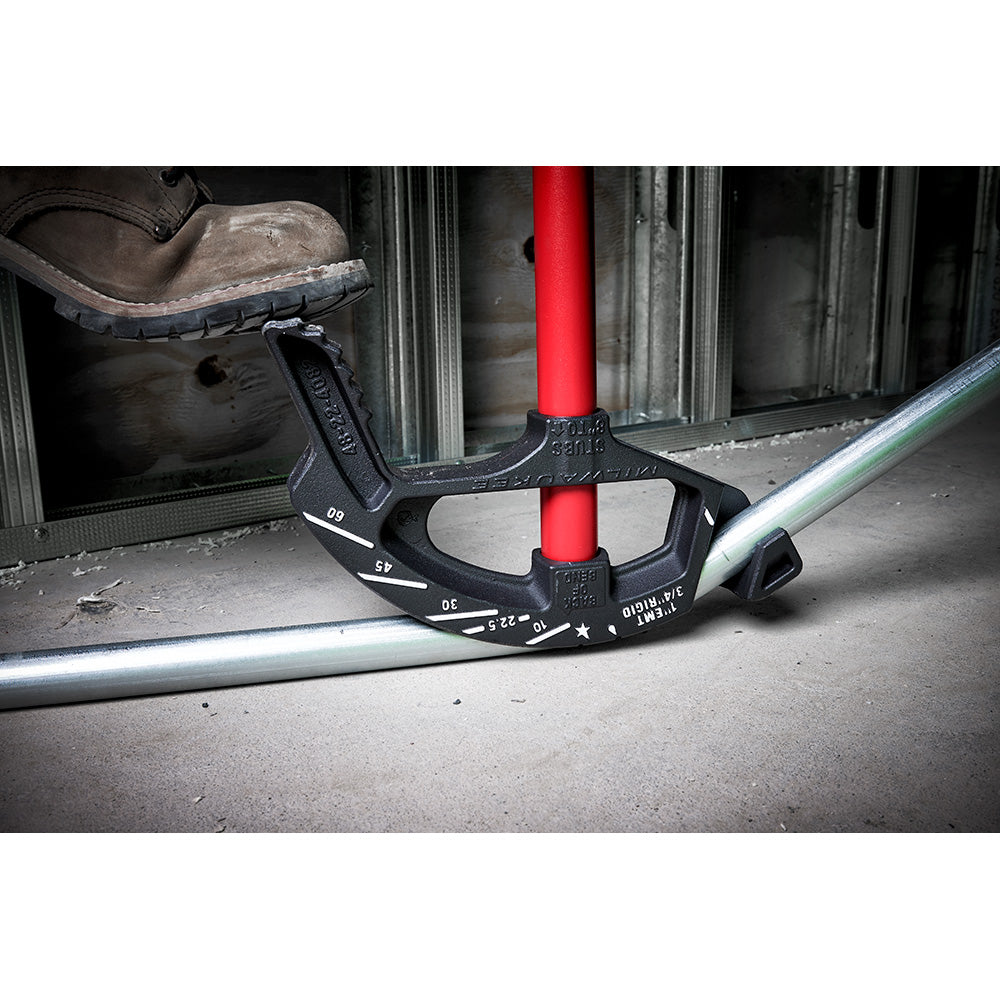 Black iron conduit bender with red pipe inserted through center, displaying angle markings on handle, positioned on metal con