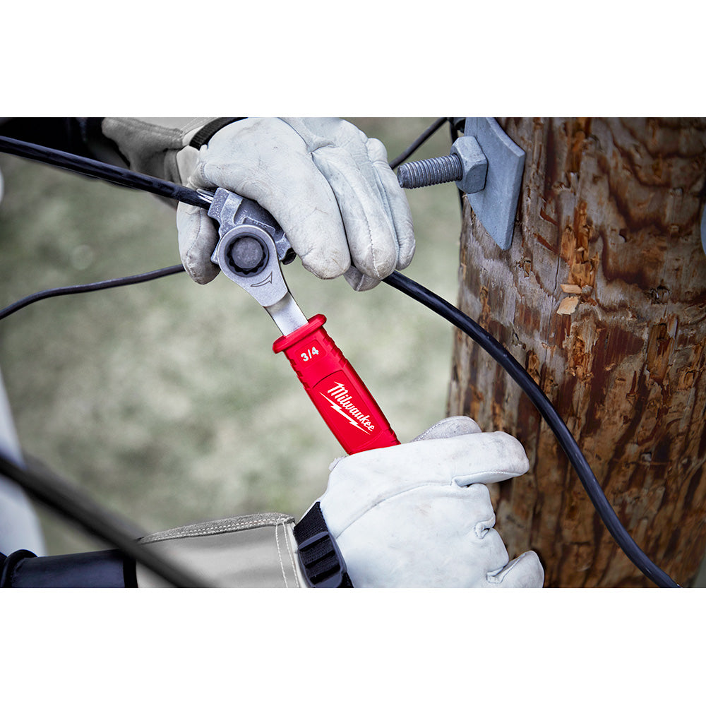 Milwaukee ratcheting box wrench with red insulated handle being used on electrical cable by gloved hands.