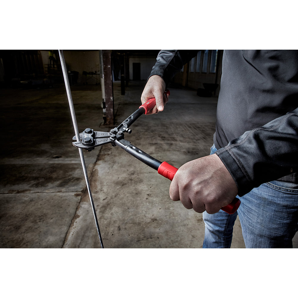Person holding bolt cutter with red handles cutting through metal bolt or chain link.