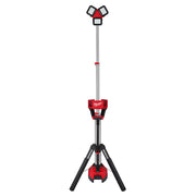 Red and black Milwaukee tower light with three adjustable LED heads on telescoping pole and tripod base.