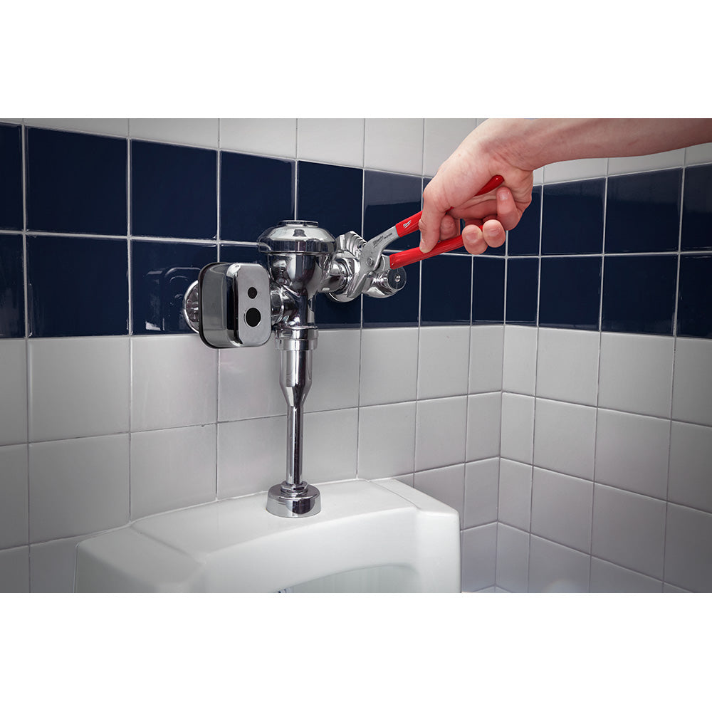 Milwaukee 10" smooth jaw pliers with red handles being held above a bathroom sink fixture.