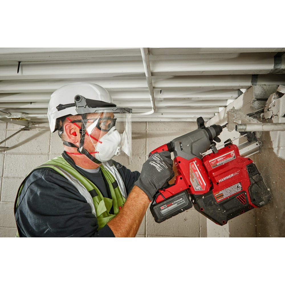 Gray hard hat with integrated clear face shield and chin strap worn by worker using power tool.