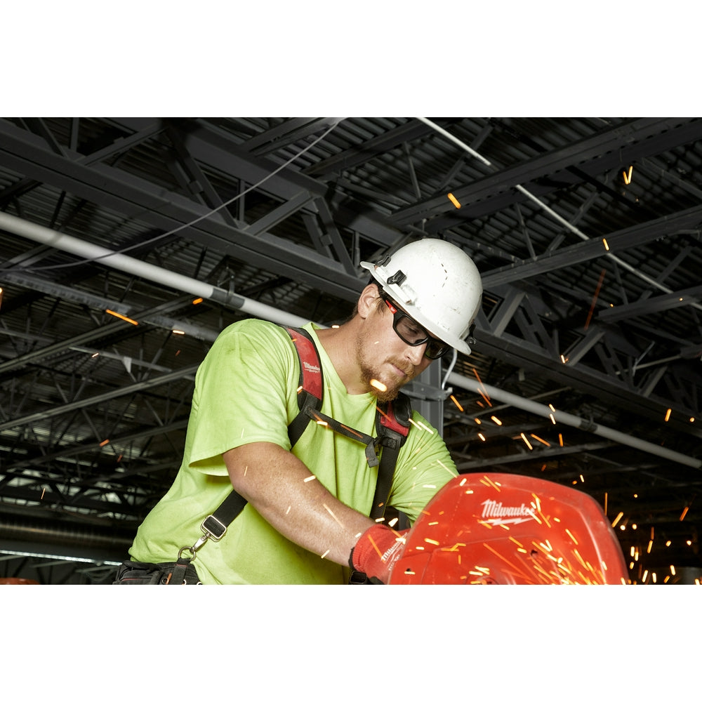 Worker wearing gray-tinted safety glasses while performing cutting work with sparks flying in an industrial setting.