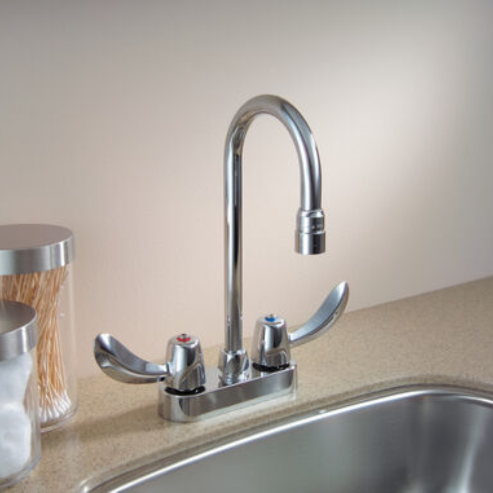 Chrome two-handle deck mount faucet with curved spout and lever handles on countertop.