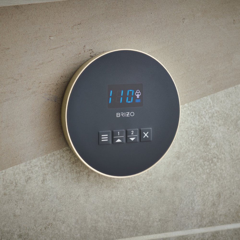 Round polished nickel steam control panel with digital display showing temperature and control buttons mounted on wall.