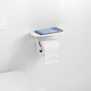 Matte white wall-mounted toilet paper holder with shelf holding a smartphone and white toilet paper roll.