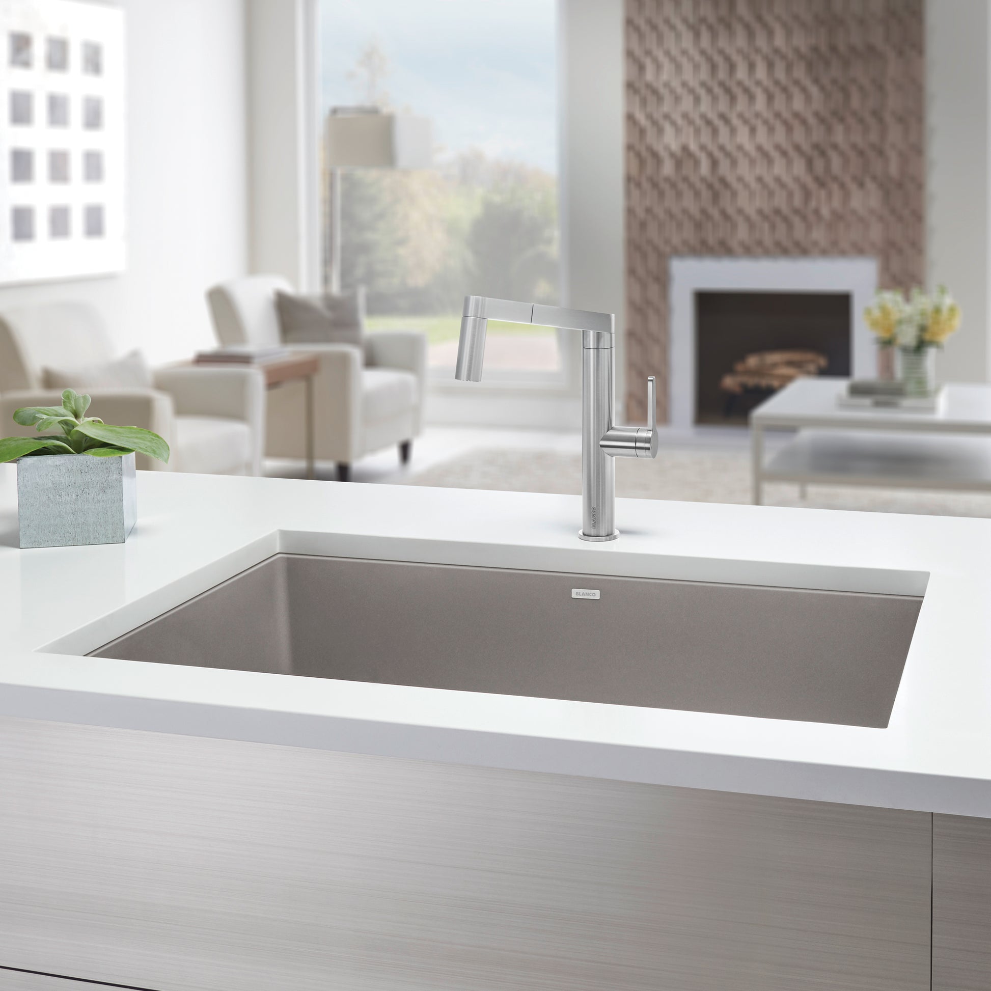 Truffle-colored undermount single bowl kitchen sink with chrome faucet installed in white countertop.
