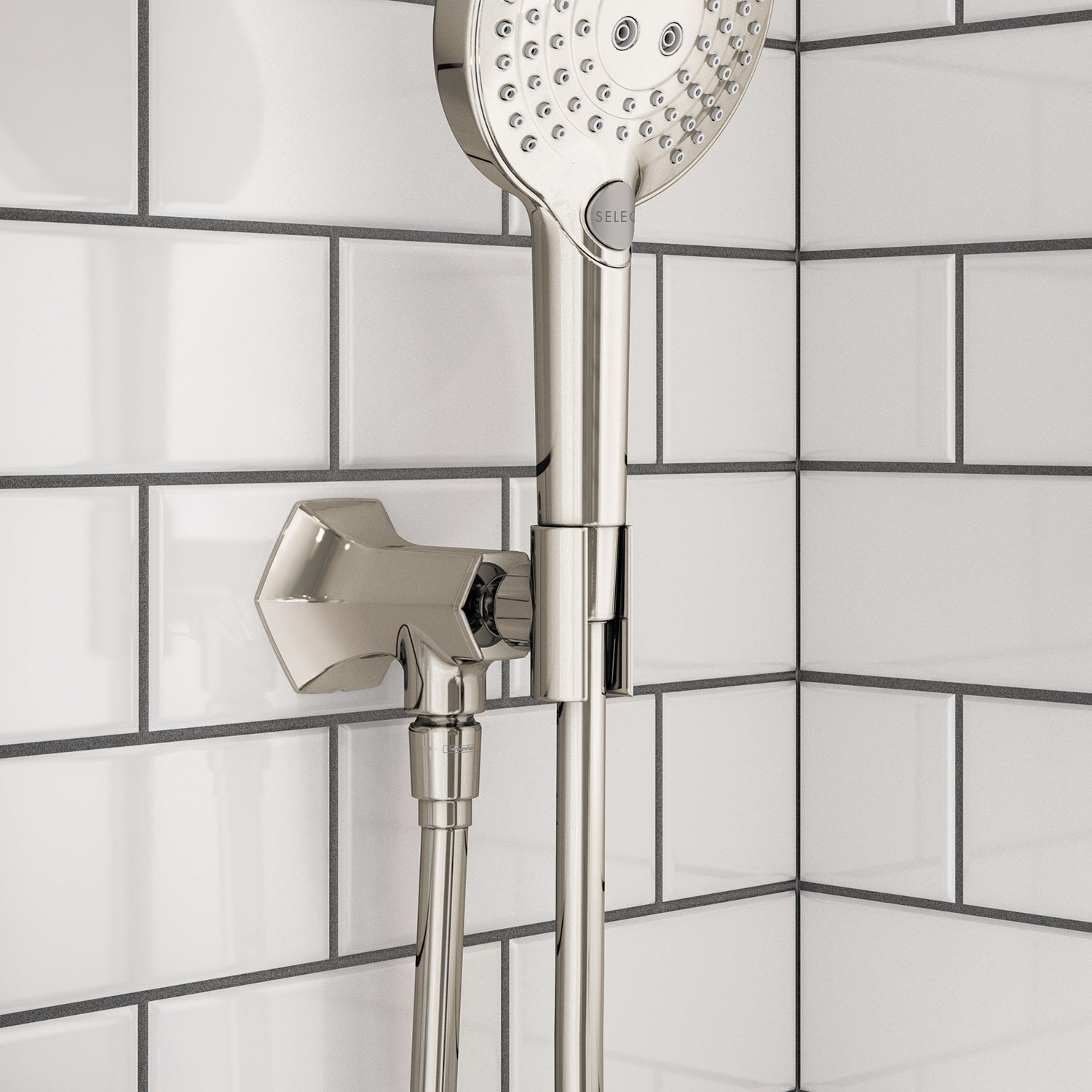 Polished nickel handshower holder with outlet mounted on subway tile wall, featuring round showerhead above.