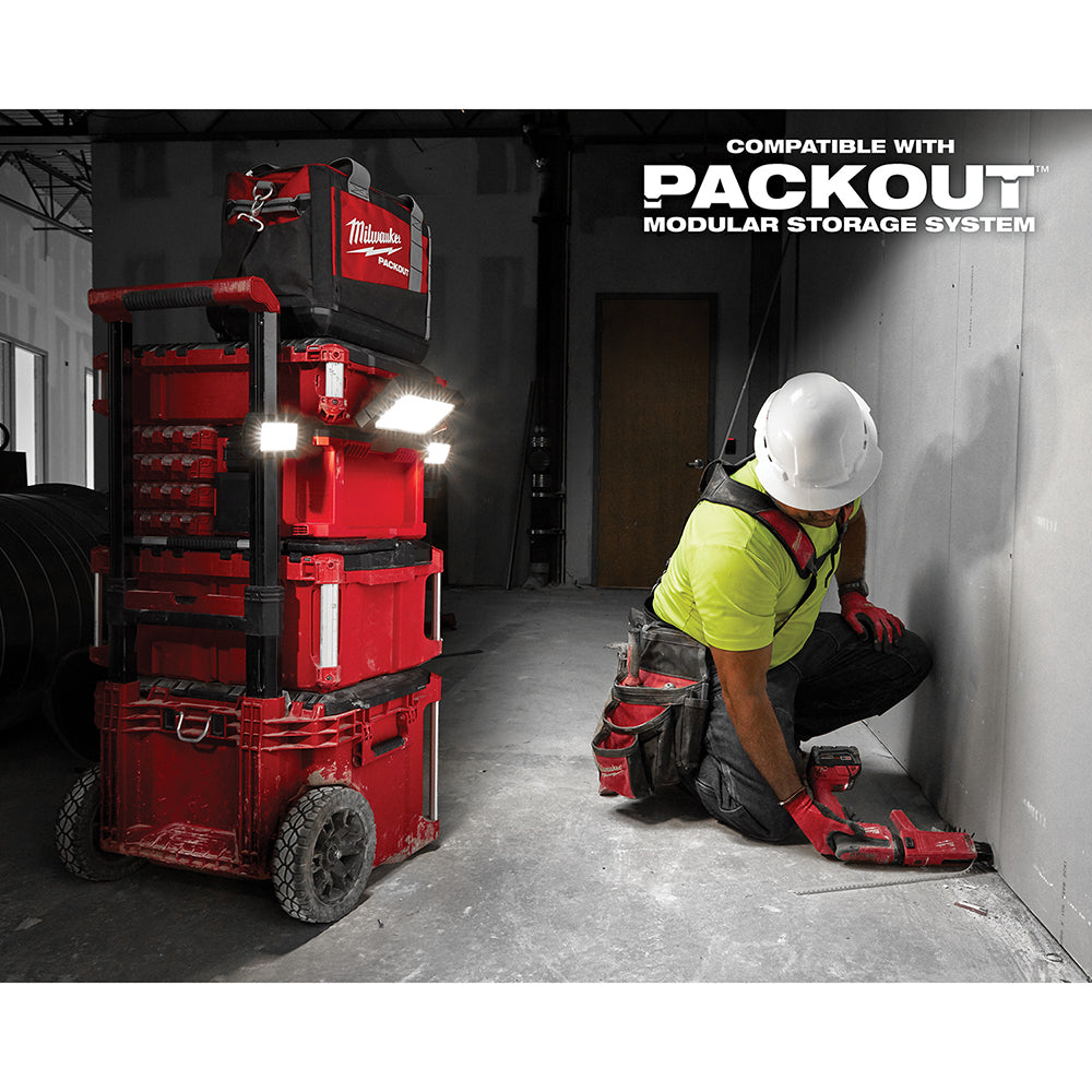 Milwaukee M18 PACKOUT light and charger with bright LED lights mounted on red modular storage unit in warehouse setting.