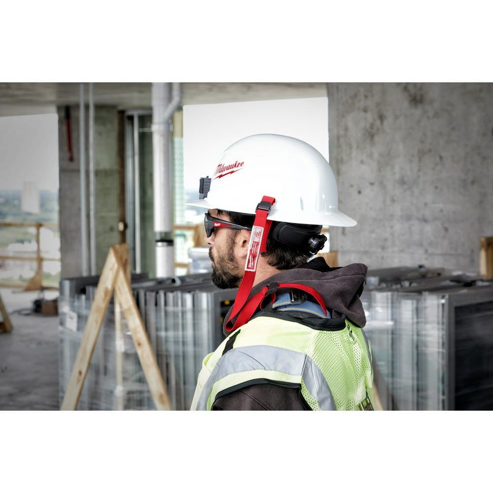 Red and black hard hat lanyard with loop attached to white Milwaukee safety helmet worn by construction worker.