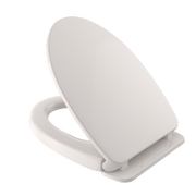White elongated toilet seat and lid with slow-close mechanism and mounting hardware visible.