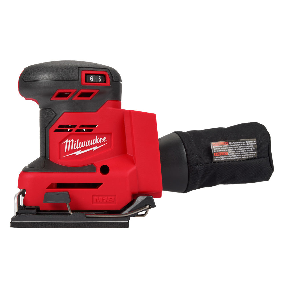 Red and black Milwaukee M18 orbital sander with dust collection bag attached to the side.