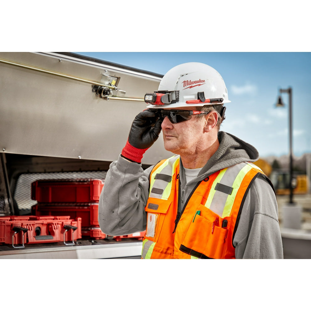 Worker wearing dark-tinted safety glasses on a construction site.