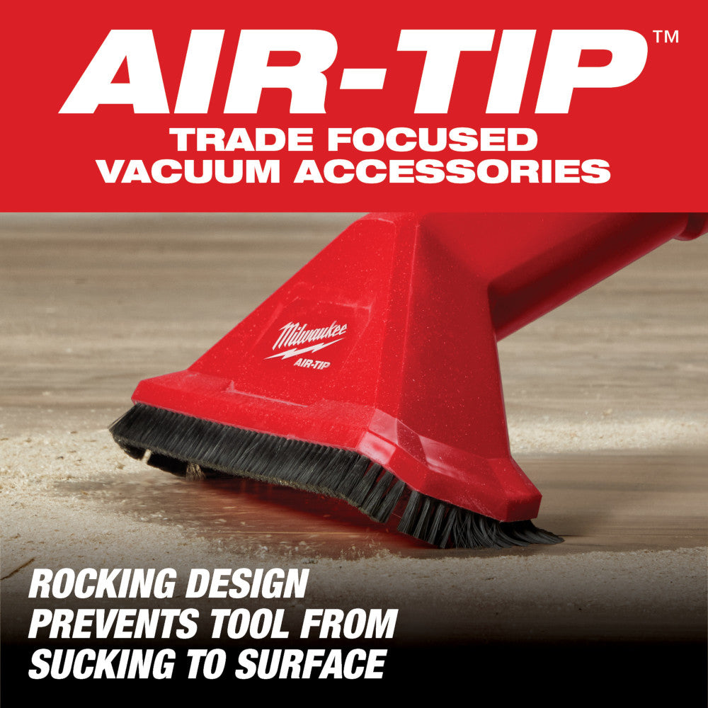 Red Milwaukee AIR-TIP rocking utility nozzle with black brush bristles on wooden floor.