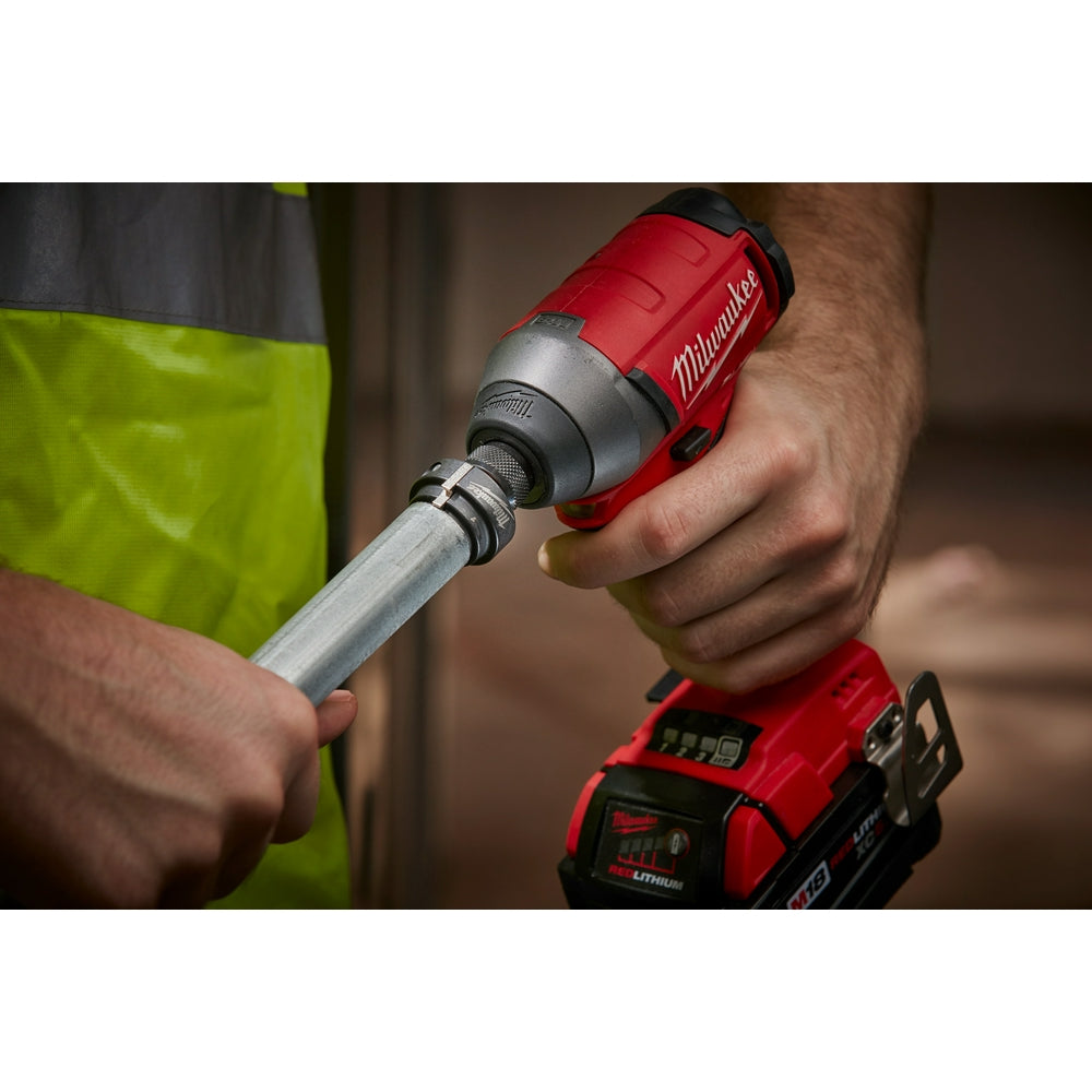 Milwaukee Shockwave conduit reamer attachment with metal cutting head held in worker's hand during use.