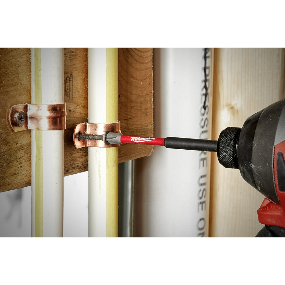 T10 impact driver bit with red and black shaft inserted into impact driver, driving screw into copper bracket on wooden surfa