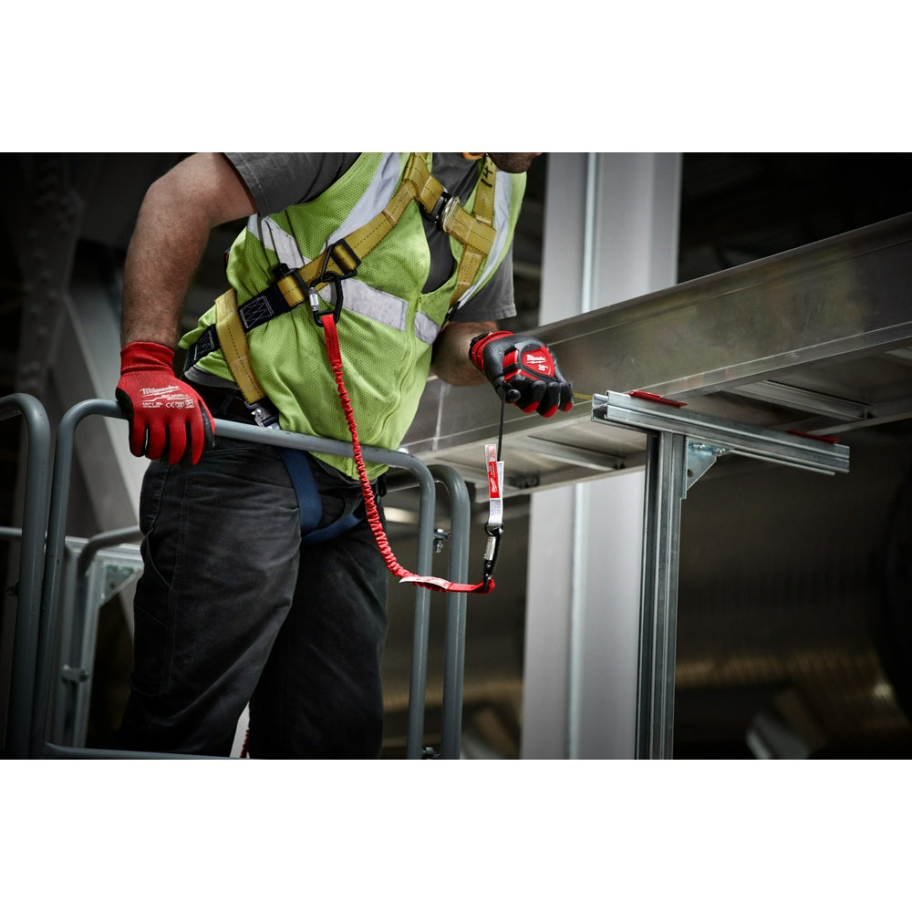 Worker in safety vest wearing red gloves using Milwaukee quick-connect accessory attached to tool belt while working on metal