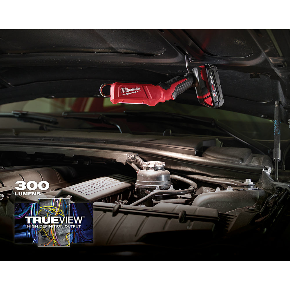 Red Milwaukee M18 LED stick light mounted under vehicle hood, illuminating engine compartment.