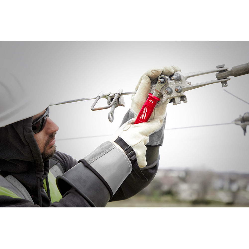 Lineman holding insulated ratcheting box wrench with red handle while working on overhead electrical lines.