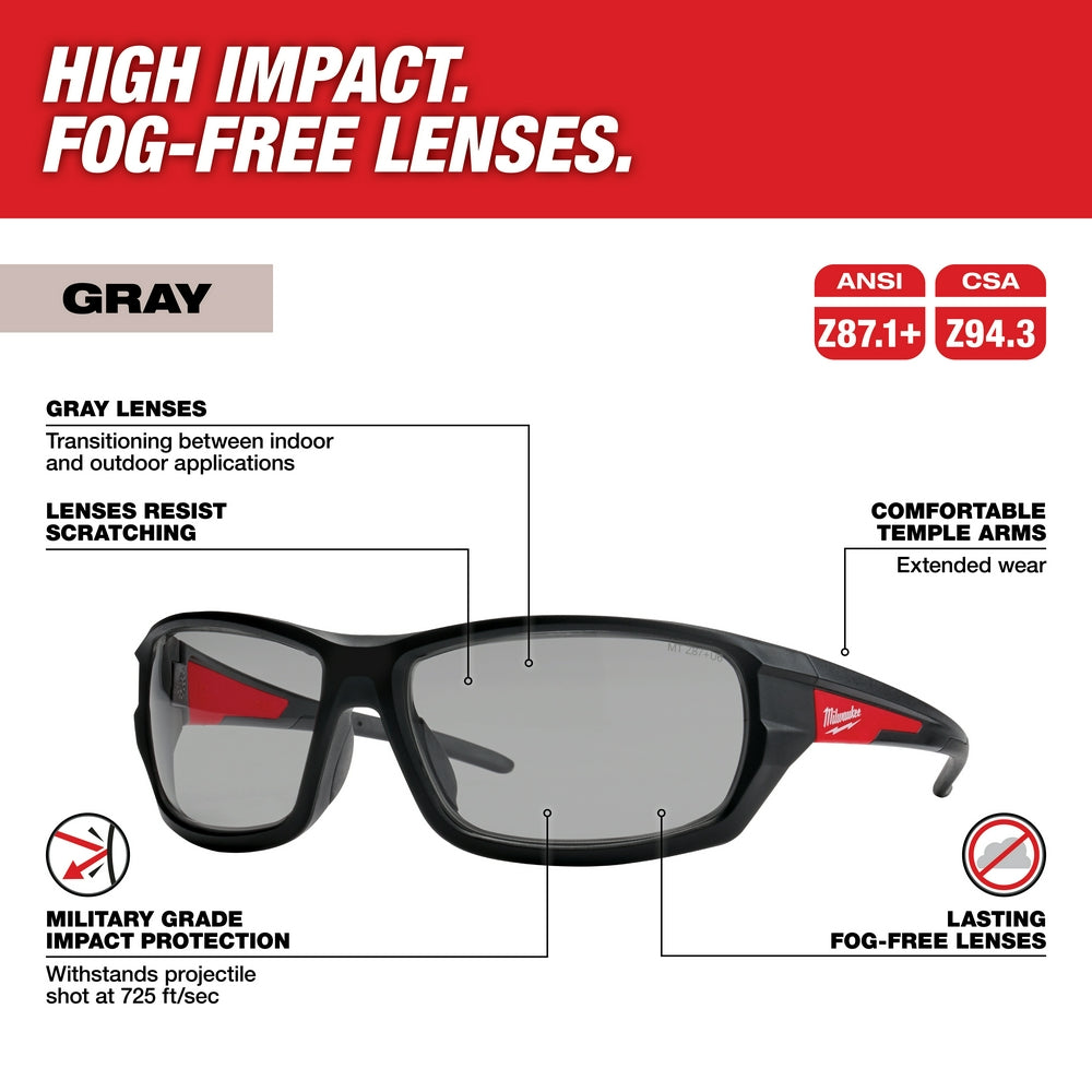 Black safety glasses with gray lenses, red temple accents, and labeled features including fog-free and scratch-resistant lens
