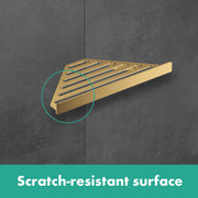 Brushed bronze triangular corner basket with horizontal bars mounted on gray tile wall.