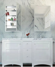 White mirrored medicine cabinet with shelves mounted above marble bathroom vanity with dual sinks.