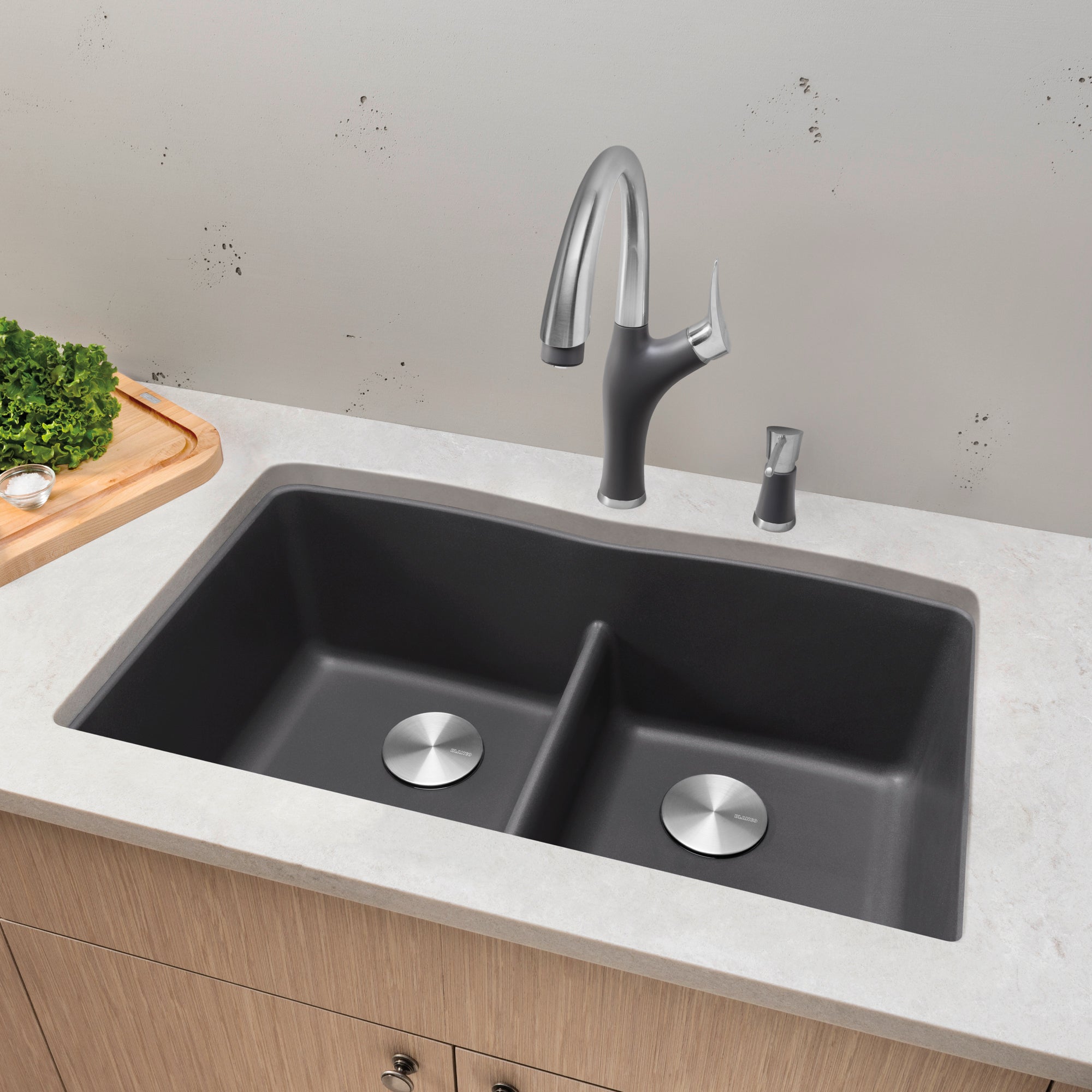 Cinder undermount double basin sink with low divider and matching pull-down faucet installed in white countertop.