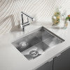 Stainless steel single bowl undermount sink with faucet and white towel, viewed from above.