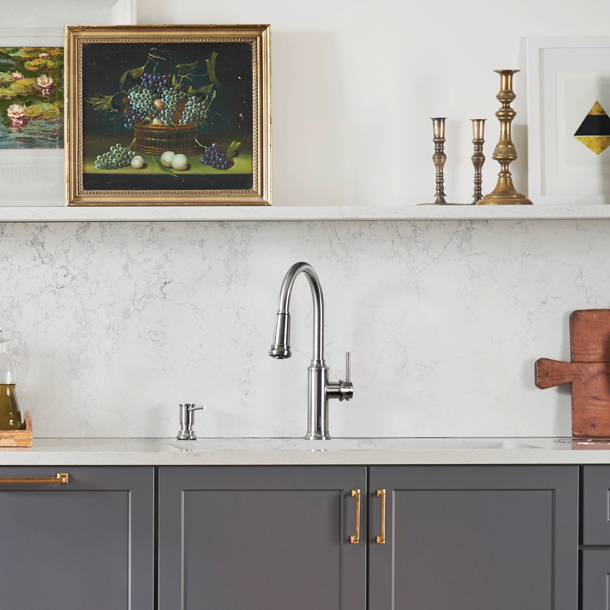 Chrome pull-down kitchen faucet with tall curved spout and single lever handle mounted on marble countertop.