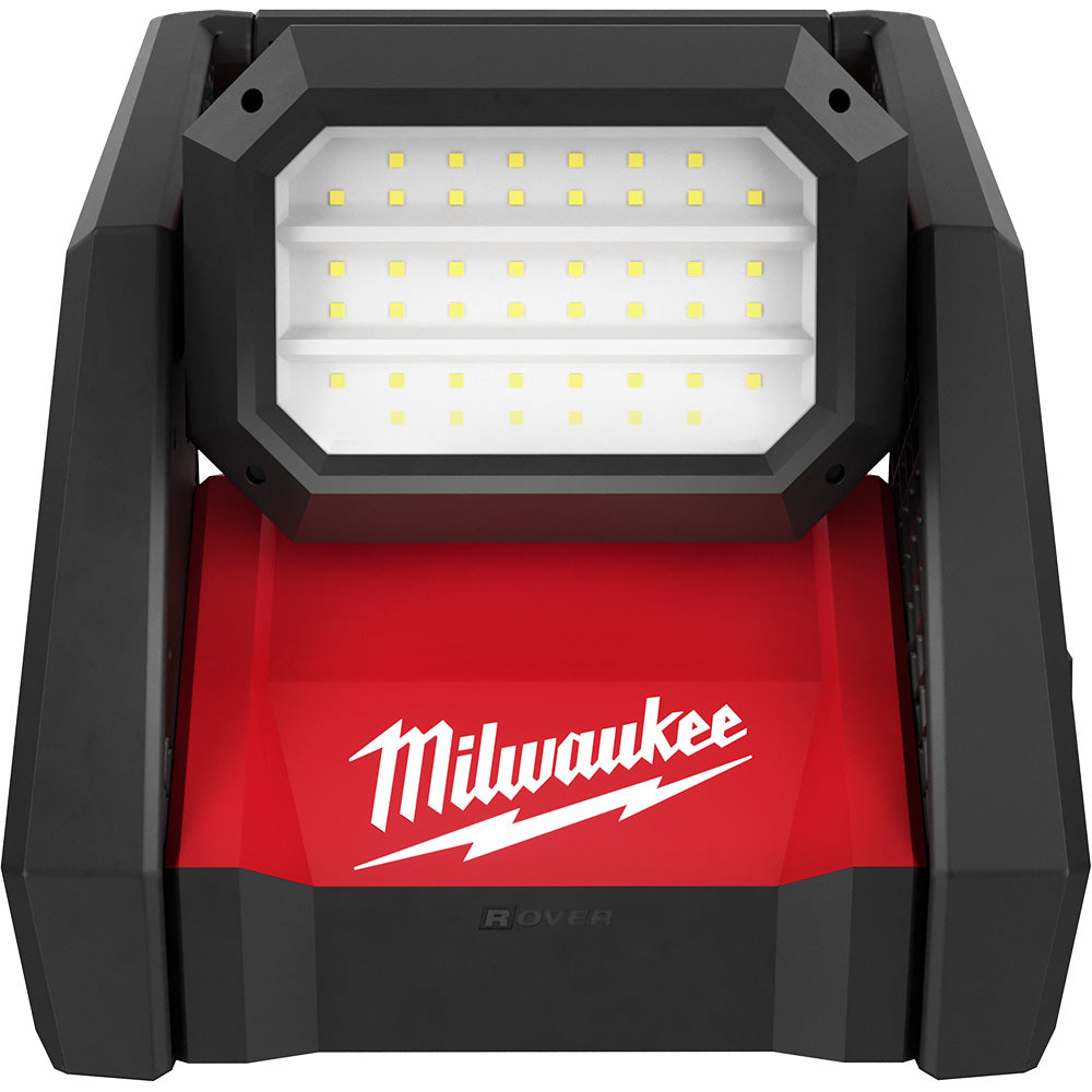 Black and red Milwaukee flood light with grid of yellow LED bulbs on white panel and Milwaukee logo on red base.