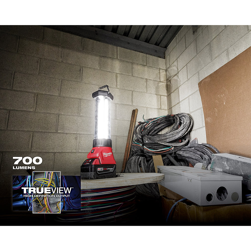 Red and black Milwaukee M18 LED lantern with handle mounted on battery base, illuminating white interior.