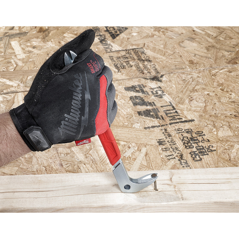 Red and gray nail puller with curved claw head being held in a gloved hand above wooden surface.