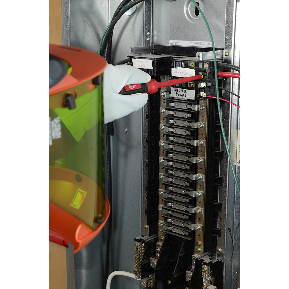 Red and black insulated screwdriver with white handle being used on electrical panel breakers.