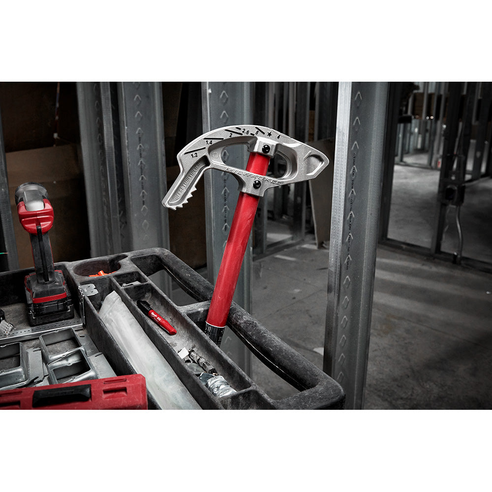 Milwaukee aluminum conduit bender with red handle and gray head, displayed in a tool tray on a jobsite.