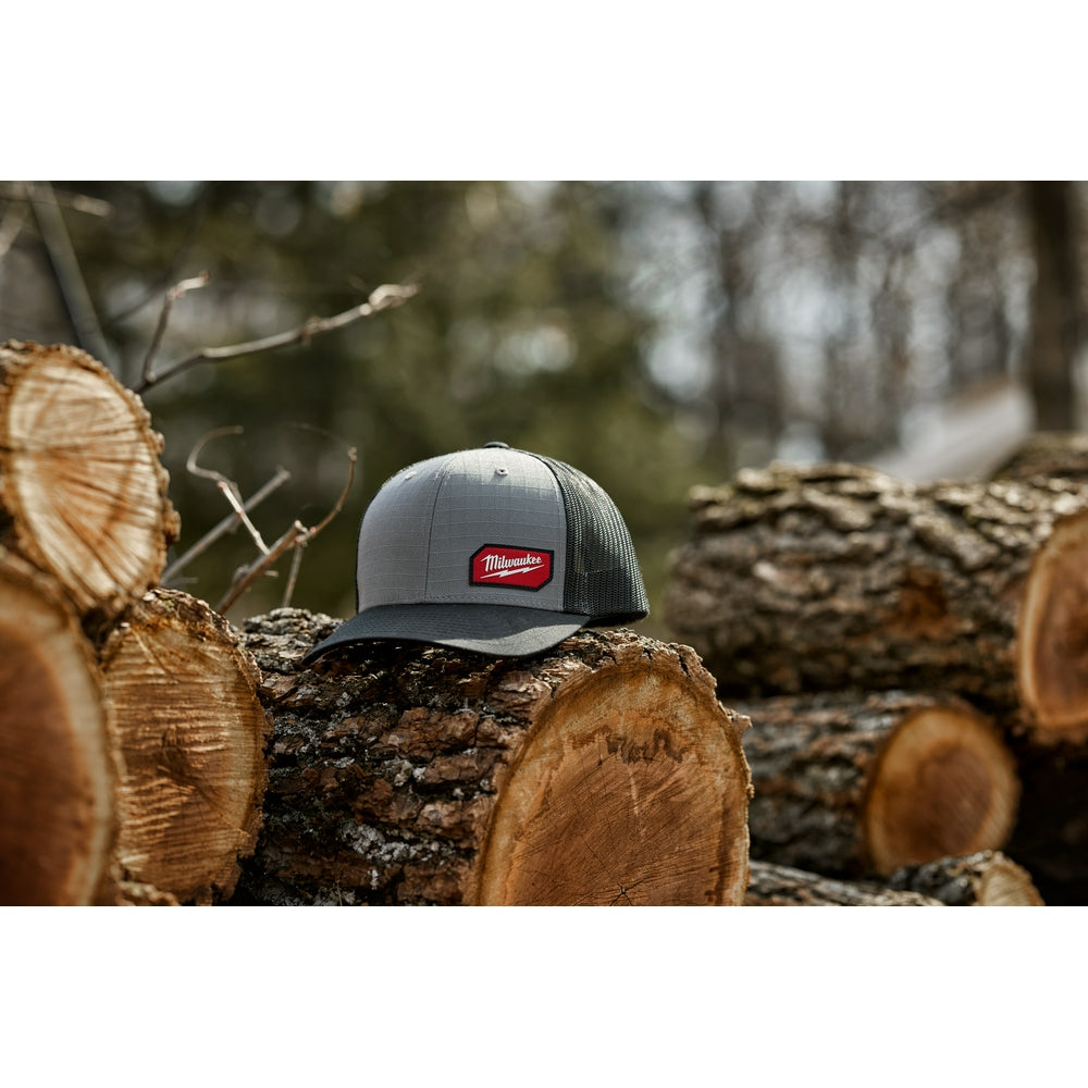 Gray trucker hat with mesh back panels and red Milwaukee logo patch on front.