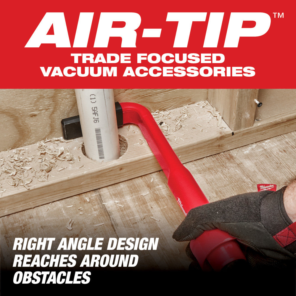 Red right-angle vacuum cleaning tool with angled nozzle being used on wooden floor with debris.