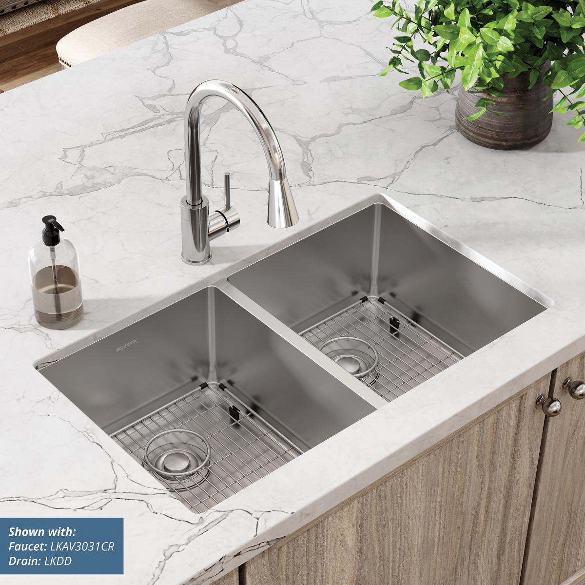 Stainless steel double bowl undermount sink with two equal-sized basins, grid inserts, and chrome faucet on marble countertop