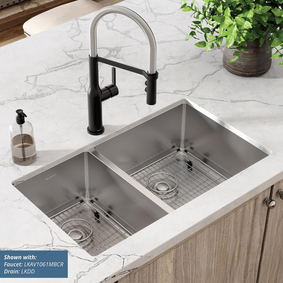 Stainless steel double bowl undermount sink with two rectangular basins and included grid strainers in marble countertop.