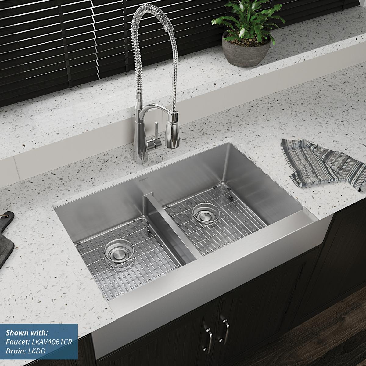 Stainless steel double bowl farmhouse sink with divider installed in countertop, paired with spiral pull-down faucet.