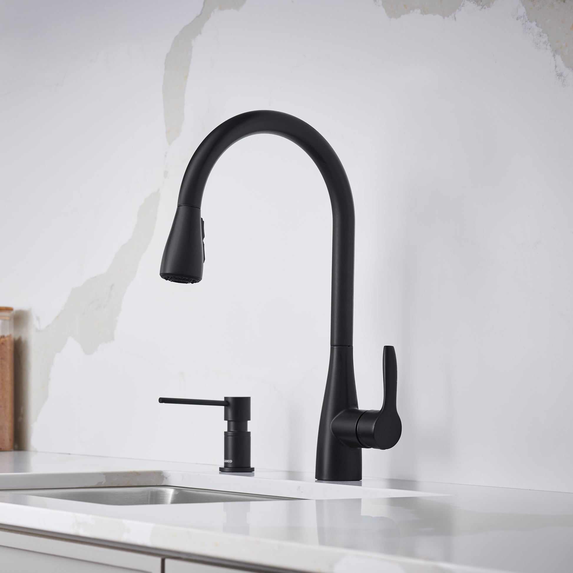 Matte black pull-down bar faucet with curved spout and single handle lever, installed over white countertop sink.