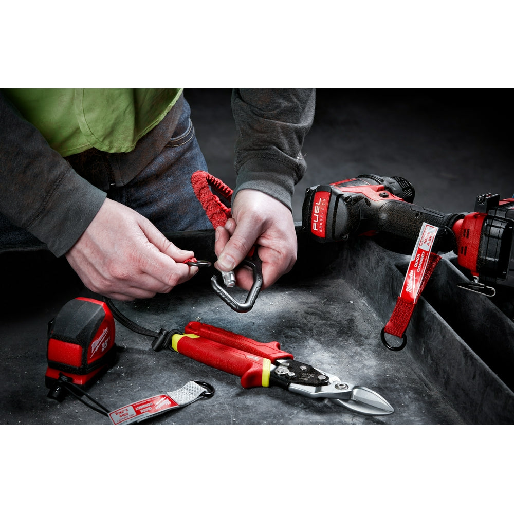 Red and black tool lanyard with quick-connect carabiner being attached to worker's wrist near various Milwaukee power tools.
