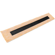 Matte black linear drain with slotted grate installed in tan tile base mat.