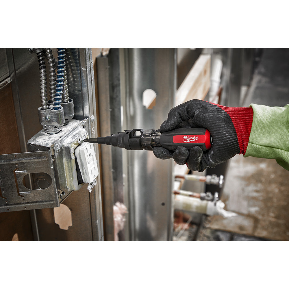 Milwaukee 48-22-2870 conduit reamer with red and black handle held in gloved hand near metal conduit.