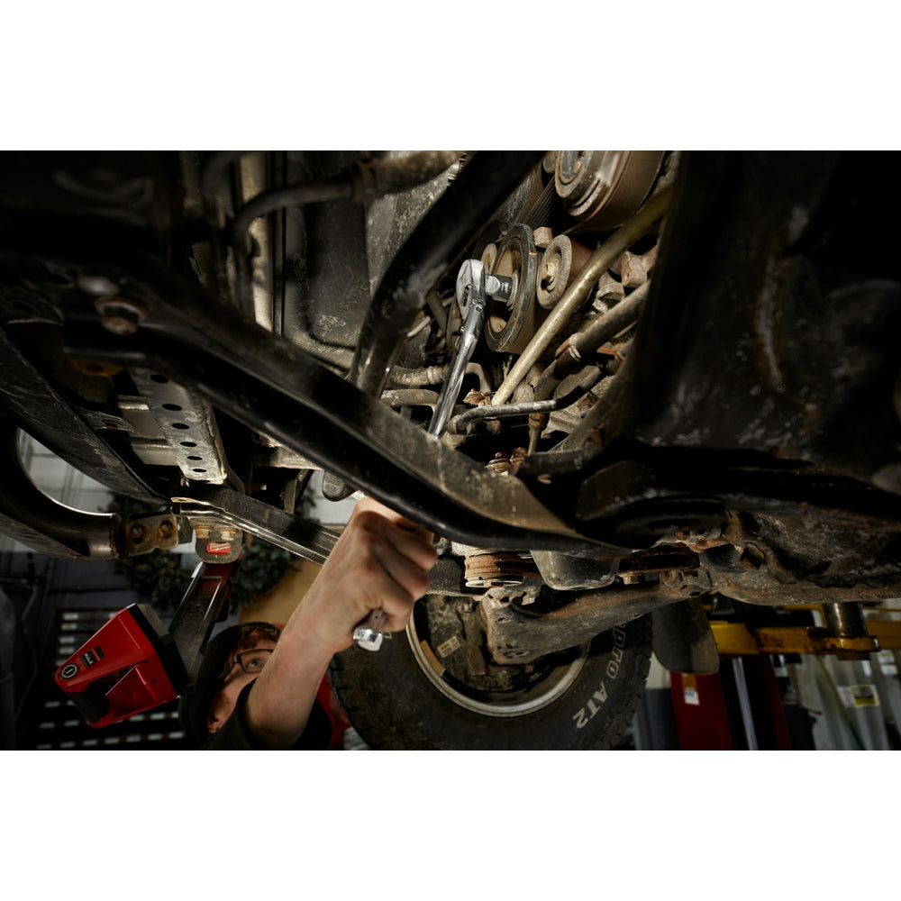 Chrome 1/2" drive ratchet with flex head being used on vehicle undercarriage during maintenance.