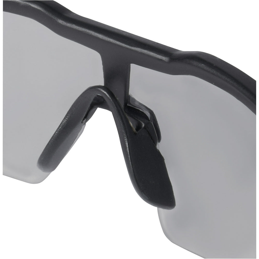 Safety glasses with gray lenses and black frame featuring adjustable temple arms.