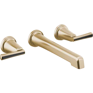 Brushed gold wall-mount lavatory faucet with two spouts and black lever handles.
