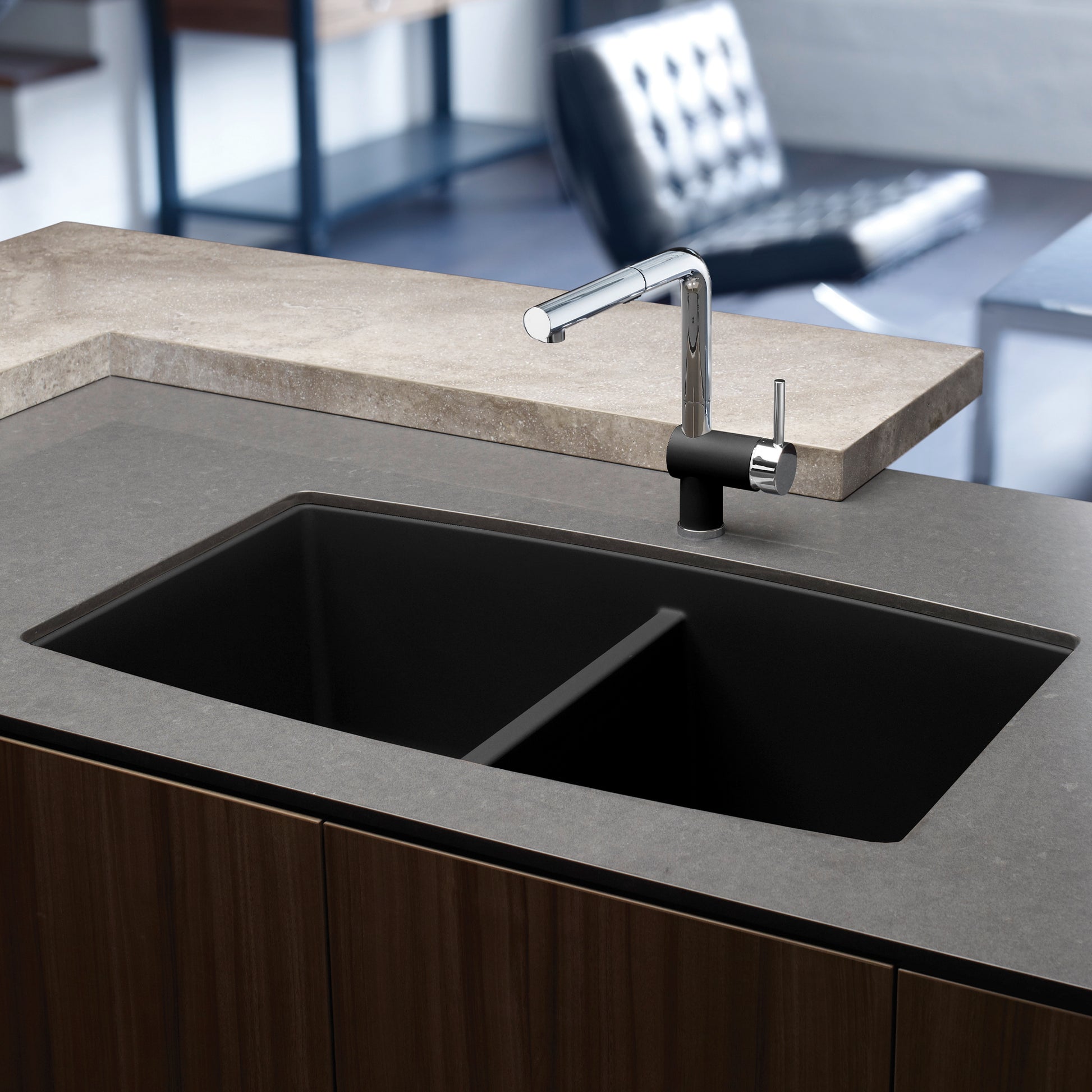 Anthracite double bowl undermount kitchen sink with chrome faucet installed in gray countertop.